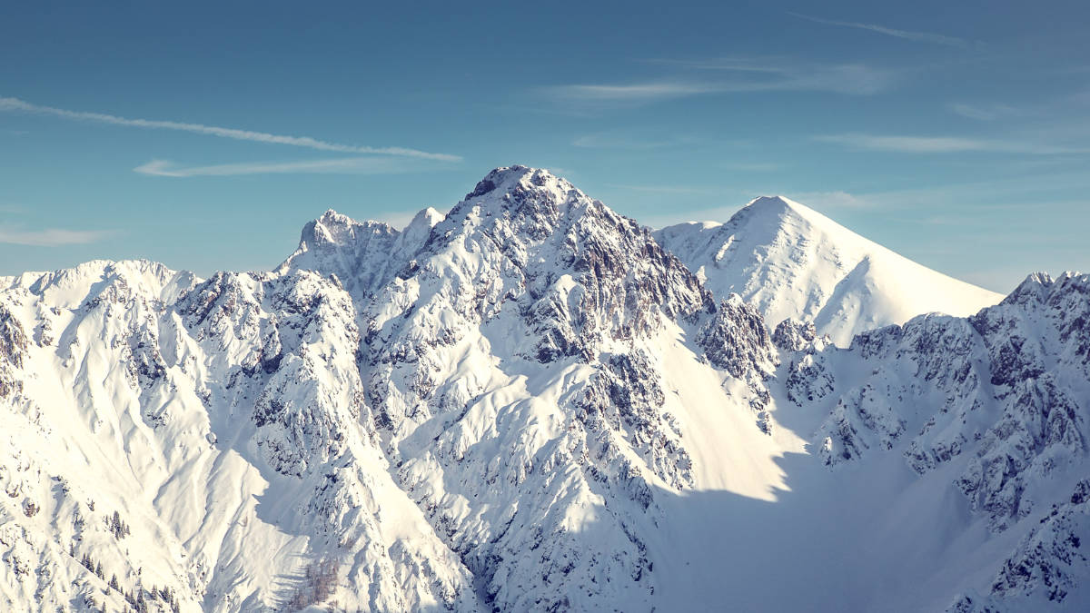 Eine Luftaufnahme der schneebedeckten Berge in den Alpen im Winter.