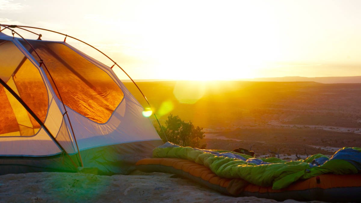 Ein Campingzelt auf einem hohen Berggipfel, Schlafsack auf einer Isomatte mit R-Wert 3 R=3
